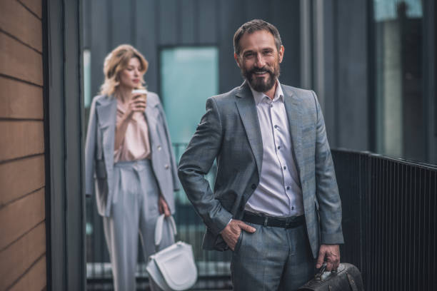 istock Successful business man with briefcase and woman behind 1319259741