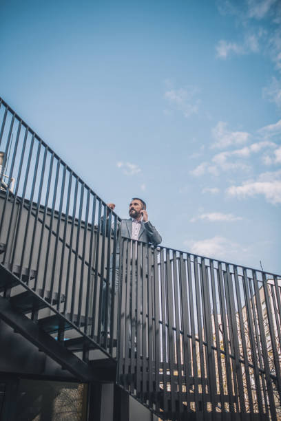 istock Man talking on smartphone climbing stairs 1319259777