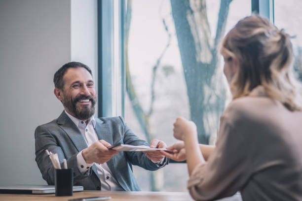 istock Joyful boss taking folder of documents from woman 1319259793
