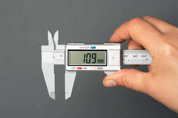 Caliper in Hand Electronic Vernier Caliper in Hand, isolated on gray background micron stock pictures, royalty-free photos & images