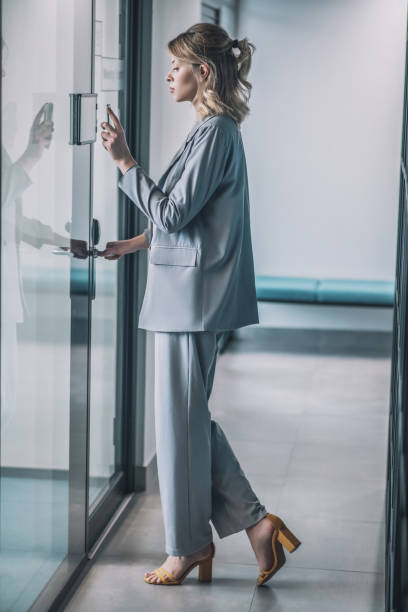 istock Woman in suit with high heels in office corridor 1319259891