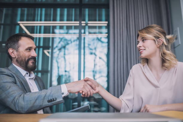 istock Smiling business man and woman sitting with handshake 1319259965