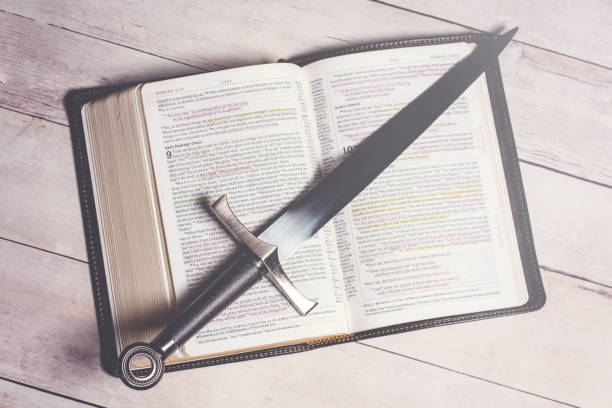 istock A Bible with a Sword on a Bright White Wooden Table 1319266383
