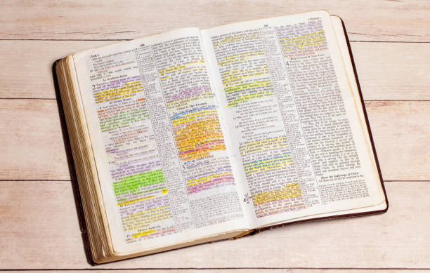 een gebruikte en gemarkeerde bijbel open op een witte houten lijst - bijbel stockfoto's en -beelden