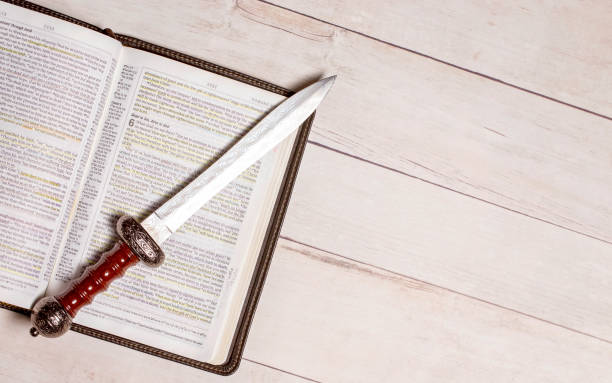 istock A Bible with a Sword on a Bright White Wooden Table 1319269933