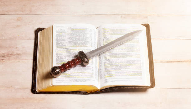 istock A Bible with a Sword on a Bright White Wooden Table 1319269936