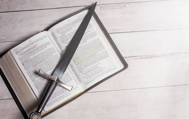 istock A Bible with a Sword on a Bright White Wooden Table 1319271277