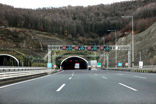 Entrance to a tunnel on a Spanish highway. Car driving by the righ channel.