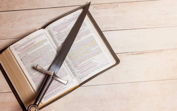 istock A Bible with a Sword on a Bright White Wooden Table 1319273559