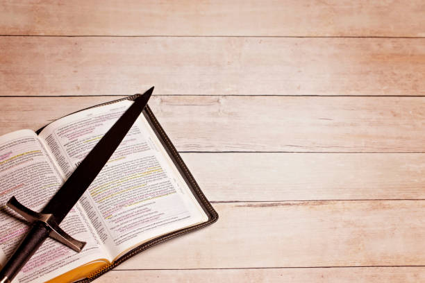 istock A Bible with a Sword on a Bright White Wooden Table 1319273560