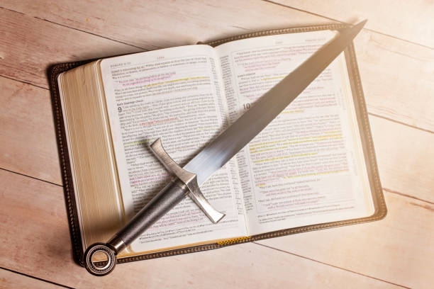 明るい白い木のテーブルに剣を持つ聖書 - religious mark 写真 ストックフォトと画像