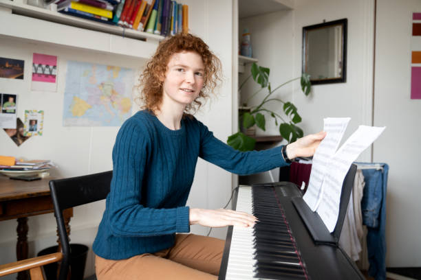 istock Young red hair woman playing keyboard 1319275291
