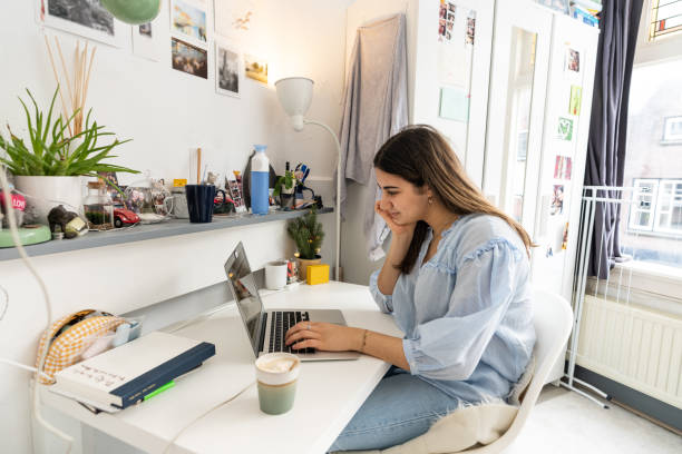 college student using laptop in dorm Young woman working from home dorm room photos stock pictures, royalty-free photos & images