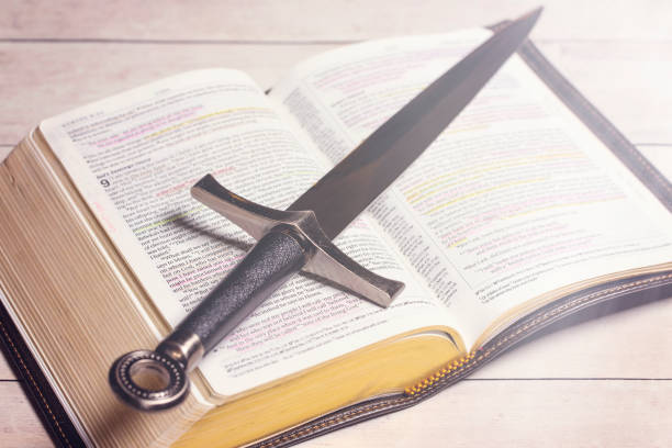 istock A Bible with a Sword on a Bright White Wooden Table 1319276523