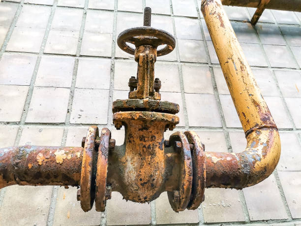vecchio tubo di ferro arrugginito e valvola di controllo sulla parete della casa - water pipe rusty dirty equipment foto e immagini stock