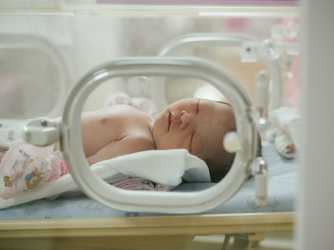 Asian female newborn baby lying in bed and sunlight in the morning.
