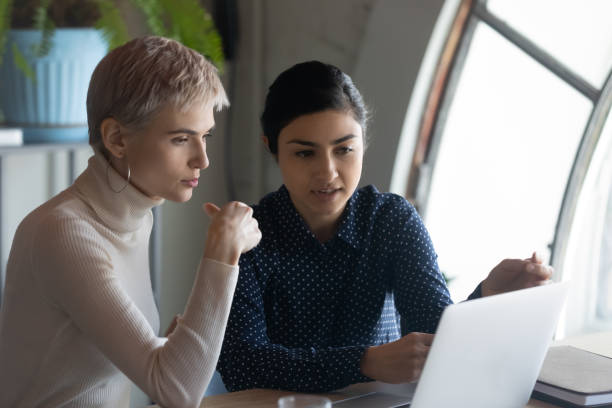 istock Multiracial female employees brainstorm on laptop in office 1319284331