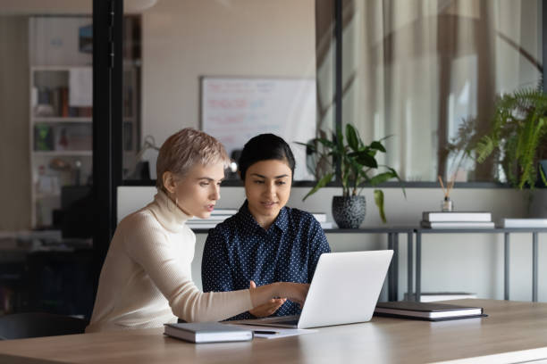 istock Multiethnic female colleagues work together discussing ideas 1319284350