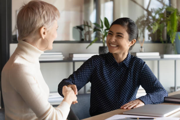istock Smiling multiracial employees shake hands at office meeting 1319284364