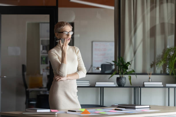 istock Confident businesswoman talk on loudspeaker in office 1319284367