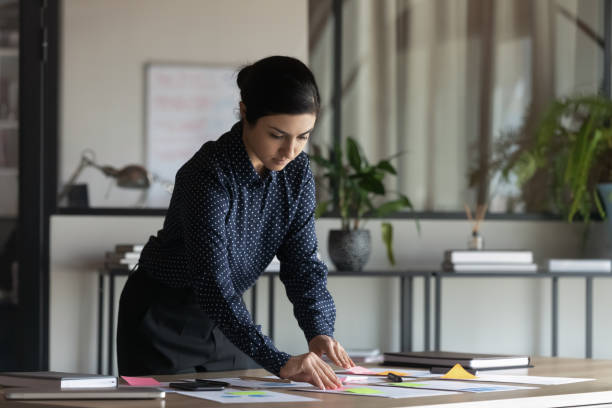 istock Young Indian female employee work on paperwork in office 1319284373