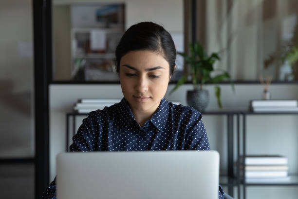 istock Young Indian woman work online on laptop in office 1319284376