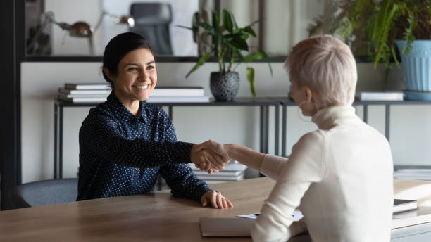 istock Smiling multiethnic female partners handshake at meeting 1319284389