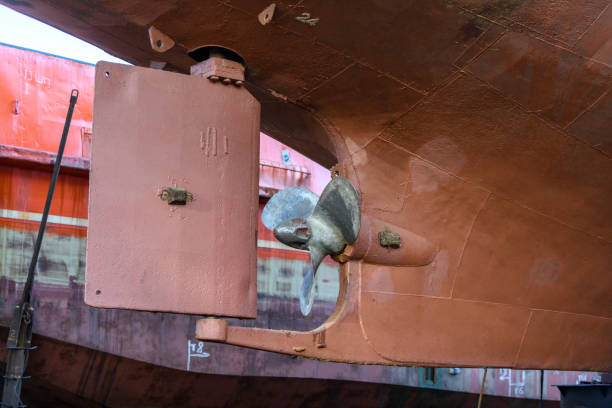Fixed blade propeller and rudder. Cargo vessel ashore on ship repairing yard.