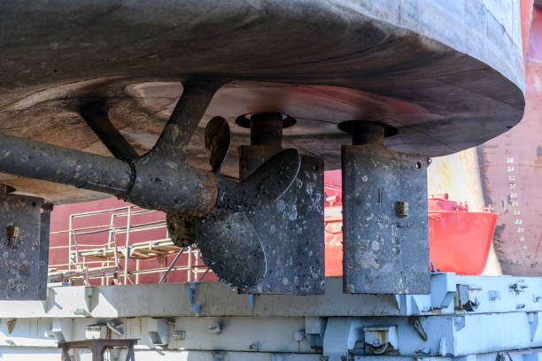 istock Fixed blade propeller and rudder with shells. Cargo vessel ashore on ship repairing yard. 1319286241