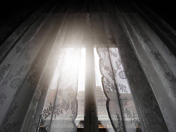 istock Sunlight coming through a window with lace curtains 1319287046