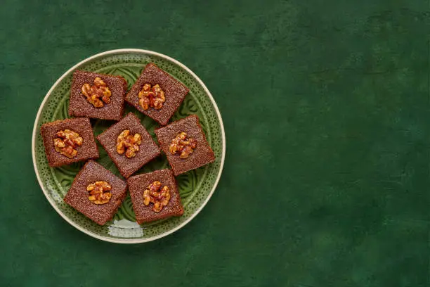 Photo of Middle eastern walnut semolina cake basbousa , namoora, hareesa . Traditional sweets celebration Eid , Ramadan . Top view with copy space