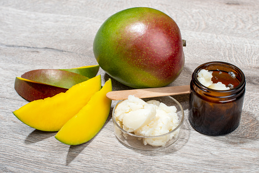 Mango butter and fresh mango fruit. Organic cosmetic, skin care, spa concept. Ingredient for home made cosmetic.