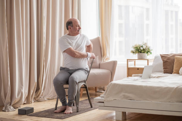 istock Sporty senior man practicing yoga using chair, doing Parivrtta Utkatasana 1319291939