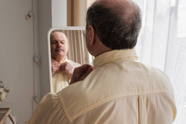 istock Mature man looking in mirror at home 1319293670
