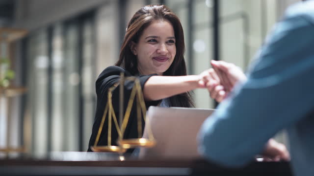 Legal consultants make agreements with clients by handshake