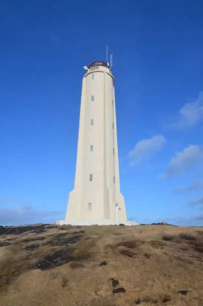 White Malarrif Lighthouse against a dark blue sky in Iceland.