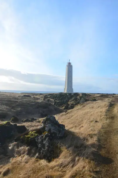 A towering white lighthouse on Snaefelssnes Peninsula in Iceland.