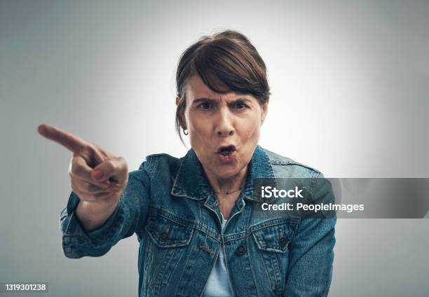 Studio Portrait Of A Senior Woman Yelling Against A Grey Background Stock Photo - Download Image Now