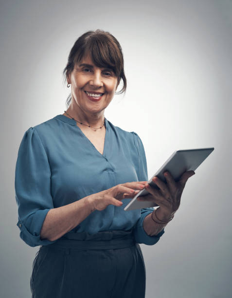 istock Studio portrait of a senior woman using a digital tablet against a grey background 1319302481