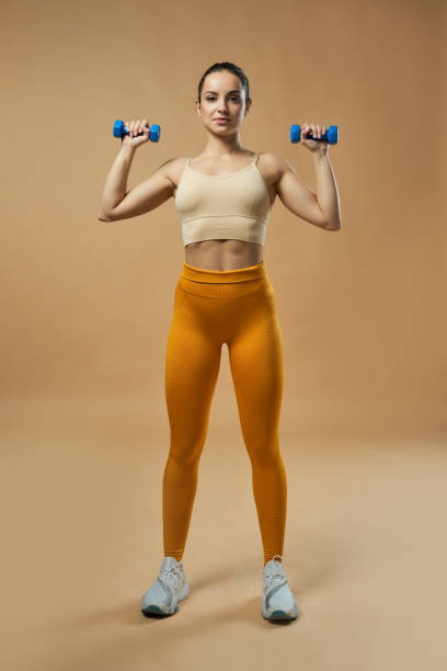 istock Beautiful fit young woman doing exercise with dumbbells 1319302509