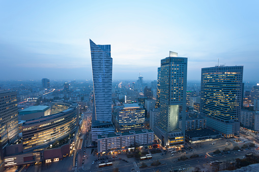 Financial and residential modern buildings illuminated at dusk, Warsaw, Poland.