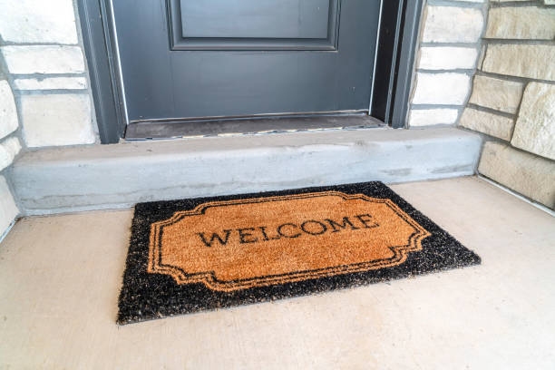 Welcome Doormat Placed In Front Of The Gray Front Door Of A Home Entrance  Stock Photo - Download Image Now - iStock