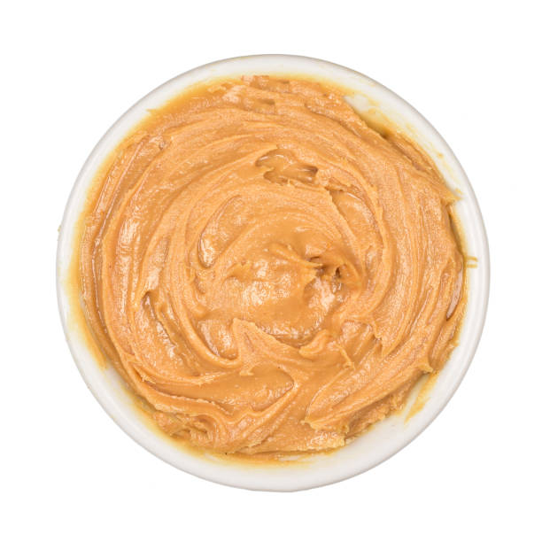 istock Peanut butter in small bowl isolated on white background, top view 1319309384