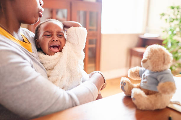 jeune mère aimante consolant sa petite fille pleurante - piquer une colère photos et images de collection