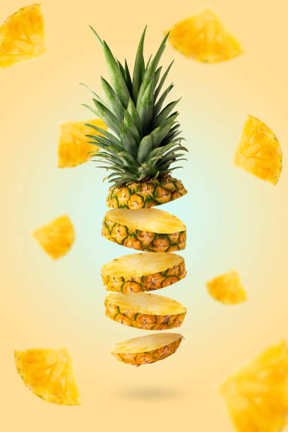 istock Fresh pineapple slices flying with pieces on yellow background 1319311021