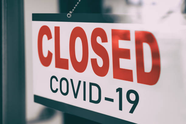 istock COVID Closed Sign hanging in window storefront. Government mandatory shutdown order of restaurants, non essential stores or curfew forcing closure of businesses leading to unemployment. Coronavirus 1319312531