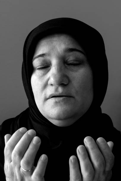 portret van turkse hoofddoekvrouw die bidt - ogen dicht closeup vrouw 50 jaar stockfoto's en -beelden