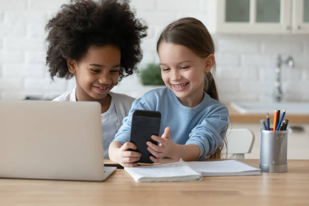 istock Happy multiethnic sisters use cellphone at home together 1319314647