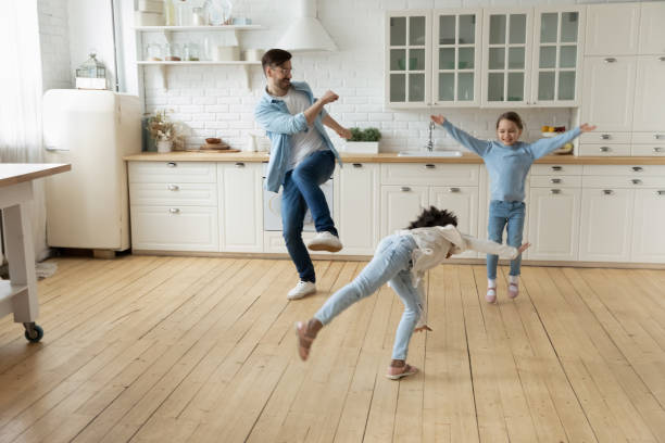 istock Happy father have fun dance with multiethnic daughters 1319314687