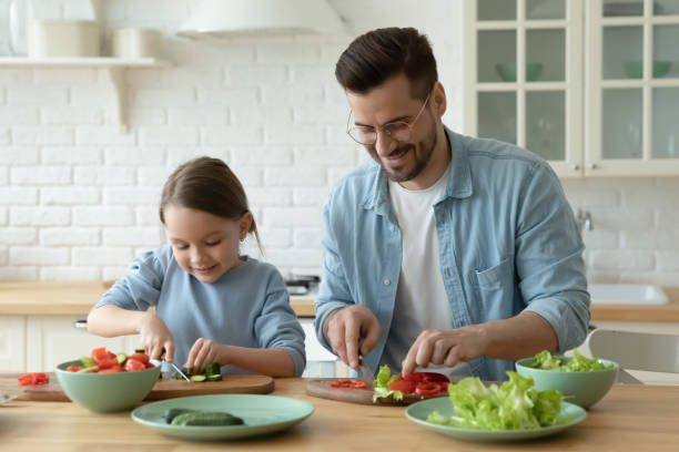 istock Young Caucasian dad and small daughter cook together 1319314720